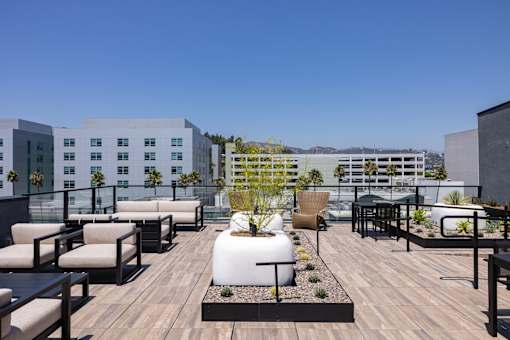 A rooftop patio with a wooden floor and furniture at Skylar At Sunset Apartments, Los Angeles, CA, 90027
