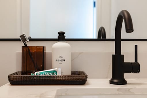 A white bottle of hand soap sits on a bathroom counter at Skylar At Sunset Apartments, Los Angeles