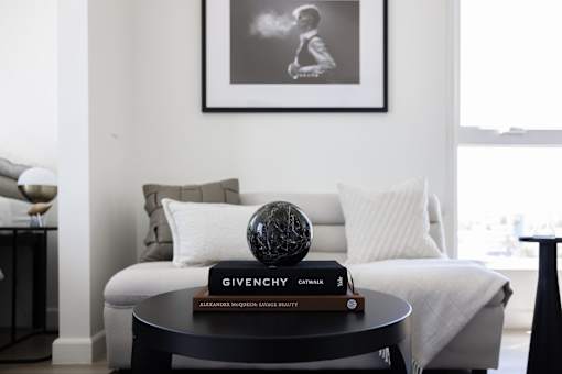 A living room with a white couch, a black coffee table, and a framed picture on the wall at Skylar At Sunset Apartments, Los Angeles 90027