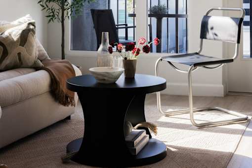 A black coffee table with a vase of flowers on it at Skylar At Sunset Apartments, Los Angeles, CA, 90027