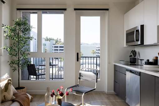 A modern kitchen with a chair and a table at Skylar At Sunset Apartments, California