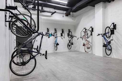 A room with a white wall and a black bicycle hanging on the wall at Skylar At Sunset Apartments, Los Angeles
