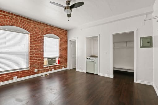 an empty living room with a brick wall