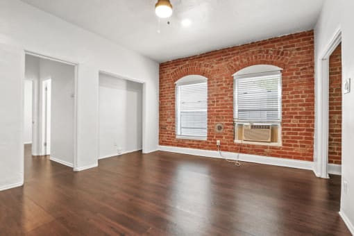 an empty living room with a brick wall