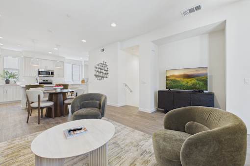 A living room with a grey couch, a white coffee table, and a painting on the wall.