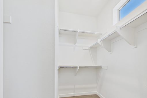 Empty white shelves in a room with a window.