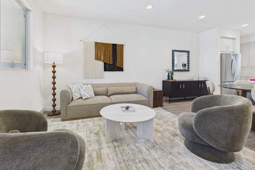 A living room with a grey couch, a white coffee table, and a grey chair.