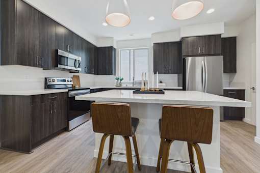 A modern kitchen with dark wood cabinets and a white island.