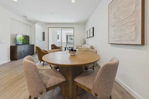 A modern dining room with a wooden table and chairs.