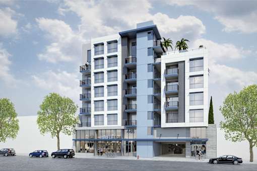 A modern apartment building with cars parked in front.