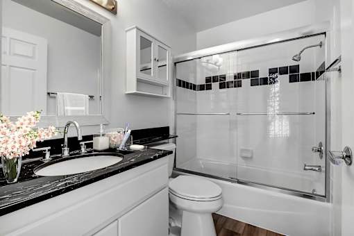 A white toilet is in a black and white bathroom.