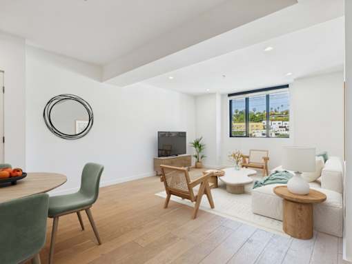 A living room with a green chair and a wooden table.