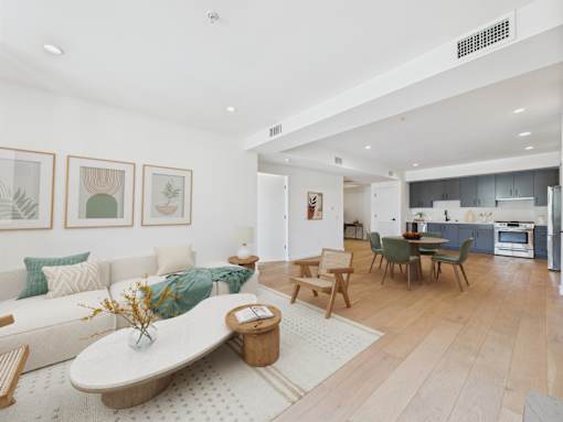 A modern living room with a white couch and a wooden coffee table.