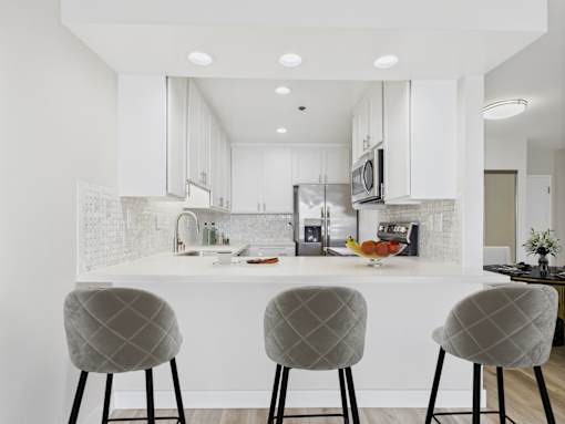 A modern kitchen with white cabinets and a white countertop.