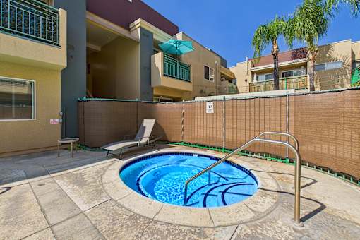 A small pool with a metal ladder sits in the middle of a patio.