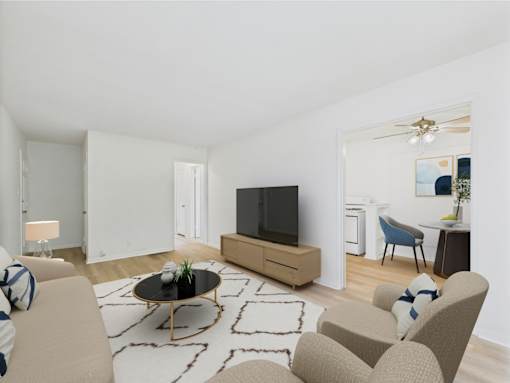 A living room with a television, chairs, and a coffee table.