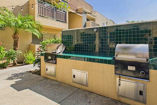 A wall with a grill and a fridge on it.