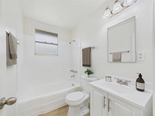A white bathroom with a toilet, sink, and tub.