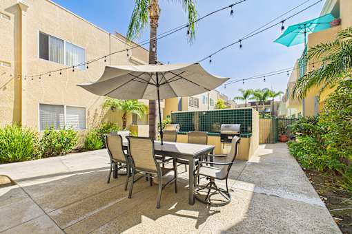 A patio with a table and chairs under an umbrella.