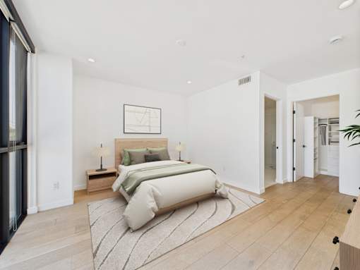 A bedroom with a large bed and a framed picture on the wall.
