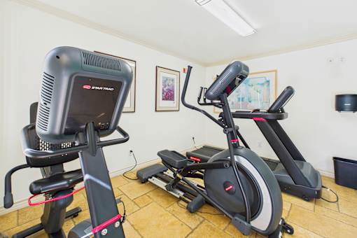 A room with a treadmill and a stationary bike.