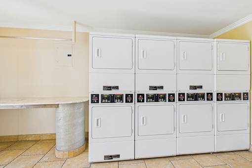 A row of white refrigerators are lined up in a room.