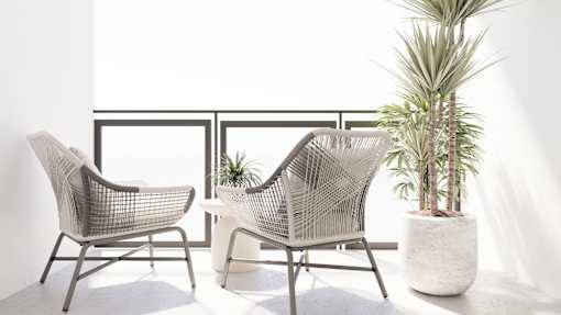 Two chairs and a plant on a balcony.