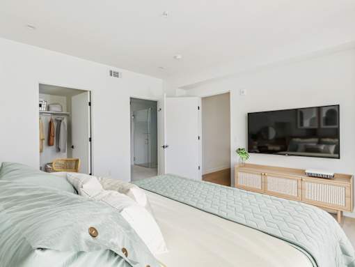 A bedroom with a bed, a TV, and a wardrobe.