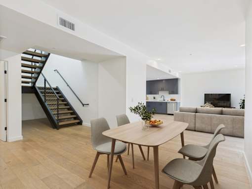 A dining room with a round table and chairs.