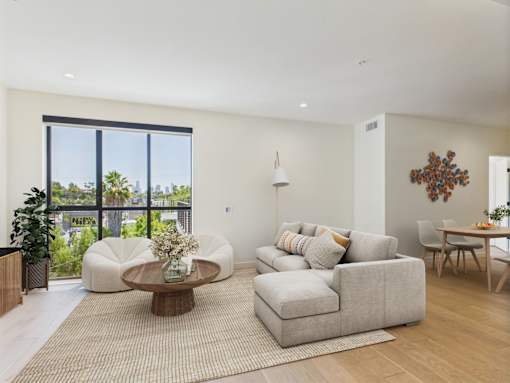 A living room with a large window and a view of the city.