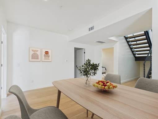 A dining room with a wooden table and chairs.