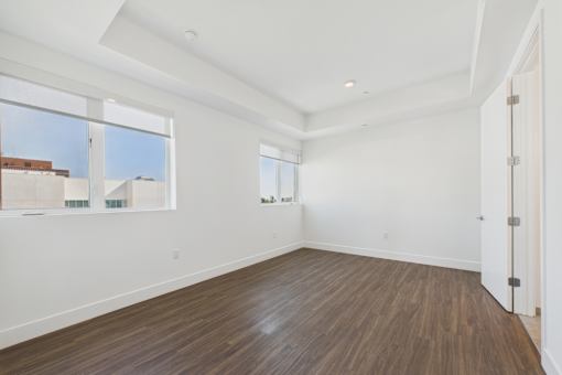 A room with wooden flooring and white walls.