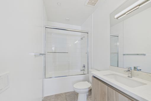 A white toilet sits next to a sink in a bathroom.