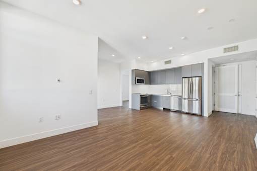 A kitchen area with a refrigerator, microwave, and oven.