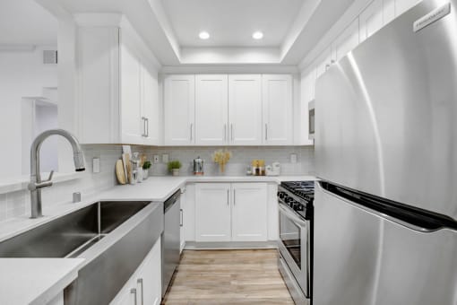 the kitchen has stainless steel appliances and white cabinets