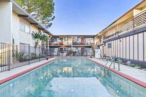 A pool in a courtyard surrounded by buildings.