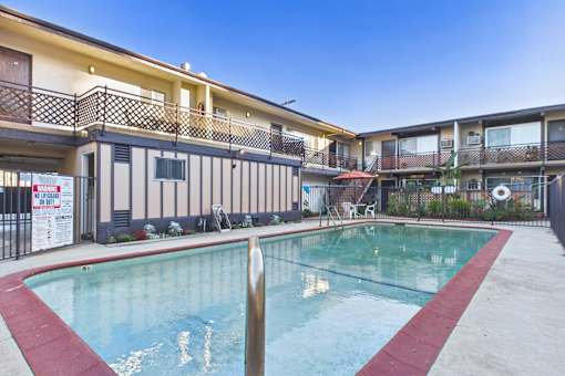 A swimming pool in front of apartment buildings.