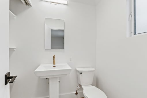 a bathroom with a sink and a toilet and a mirror