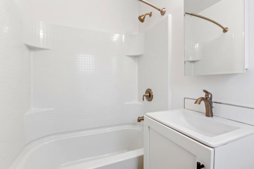 a white bathroom with a sink and a bath tub