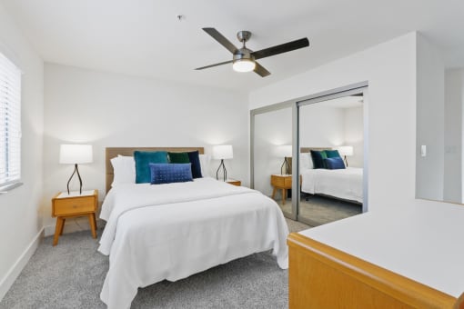 a bedroom with a bed and a ceiling fan