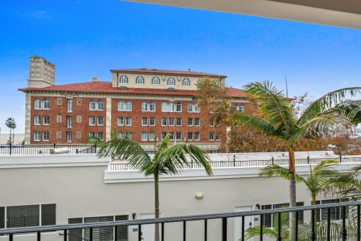 a view of a building from a balcony with palm trees