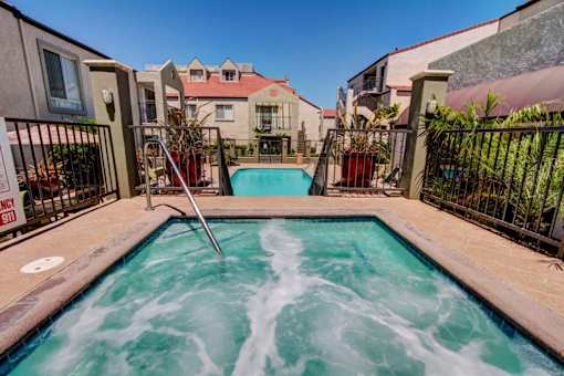 A hot tub in the middle of a courtyard surrounded by buildings.