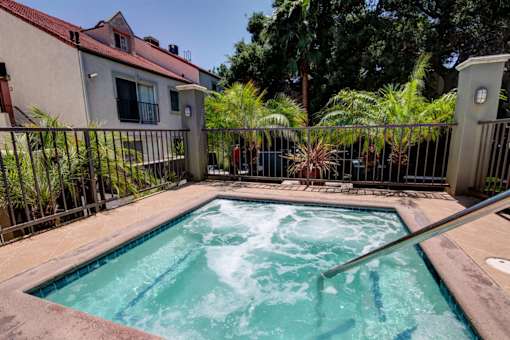 A hot tub sits in the middle of a patio.