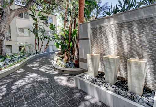 A pathway with a water feature and a building in the background.