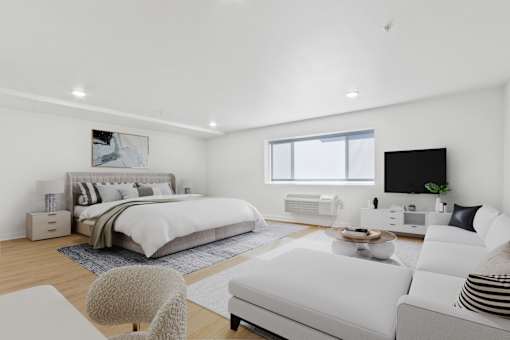 A modern bedroom with a large bed and a white couch.
