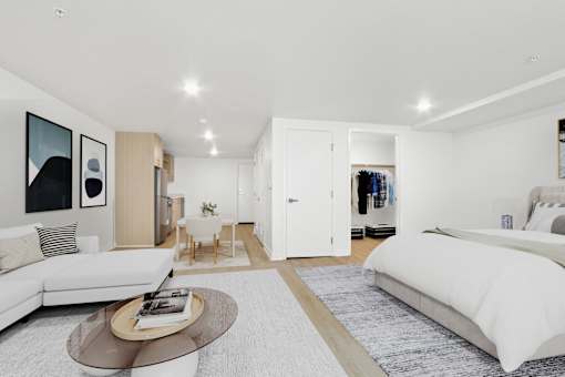 A modern bedroom with a large bed and a white couch.