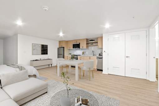 A modern kitchen with white cabinets and a dining table.