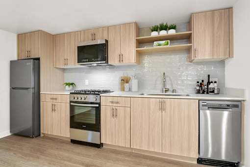 A modern kitchen with wooden cabinets and stainless steel appliances.