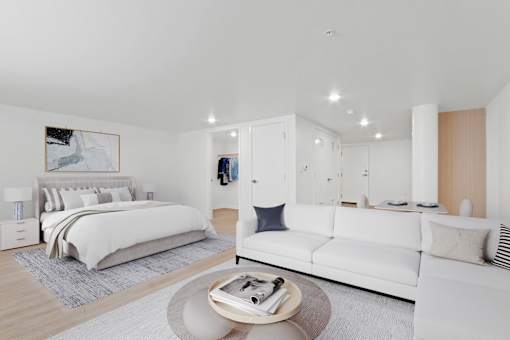 A modern bedroom with a large bed and a white couch.