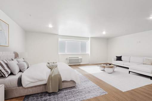 A modern bedroom with a large bed and a white couch.